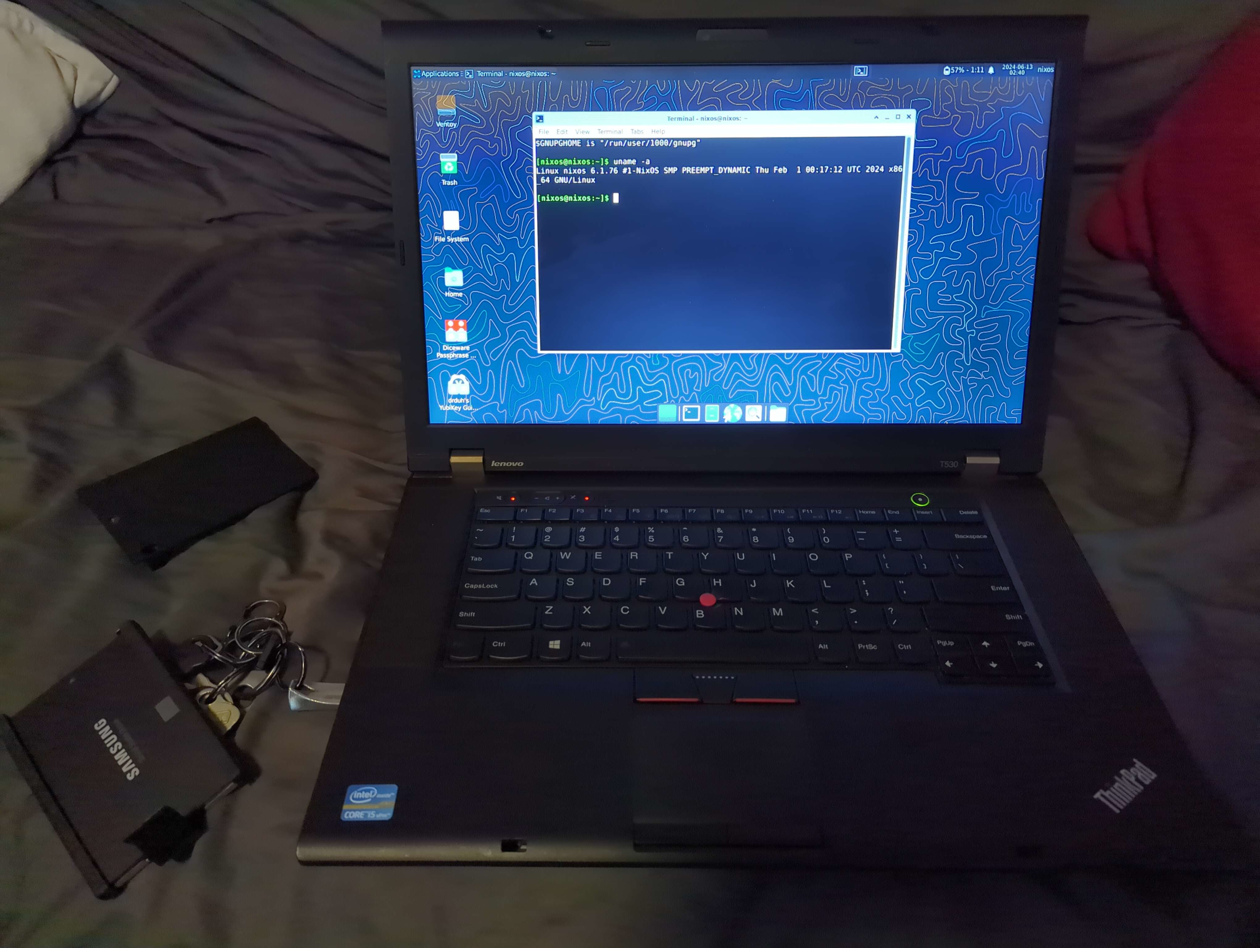 A picture showing a ThinkPad T530 booted into a NixOS live image with the Xfce4 desktop. There is a terminal open with the output of the uname -a command